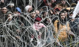 Des migrants derrière des barbelés à la frontière entre la Turquie et la Grèce près de des Kastanies, en Grèce, le 2 mars 2020
