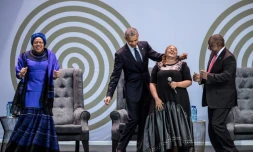 L'ex président américain Barack Obama, la veuve de Nelson Mandela, Graça Machel (à gauche) et le président sud-africain Cyril Ramaphosa (à droite) dansent en compagnie de la chanteuse Thandiswa Mazwai lors d'une cérémonie en l'honneur de Mandela, le 17 juillet 2018 à Johannesbourg