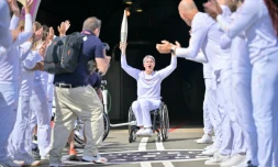 Emmanuelle Assmann, médaillée en escrime-fauteuil, brandit la flamme paralympique 
au terme d'une traversée inédite par le tunnel sous la Manche, le 25 août 2024 à Coquelles dans le Pas-de-Calais