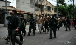 Des policiers escortent des criminels présumés arrêtés lors d'une opération dans la favela de Vila Cruzeiro, dans le complexe de Penha, à Rio de Janeiro, le 28 octobre 2025 au Brésil