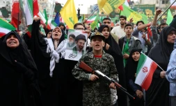 Un jeune Iranien en uniforme militaire brandit un fusil factice lors d'un rassemblement des partisans du pouvoir, le 29 avril 2029 à Téhéran