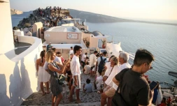Des touristes attendent le coucher du soleil dans le village d'Oia sur l'île grecque de Santorin, le 20 juillet 2024