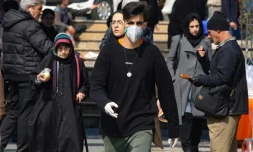 Des piétons, certains portant un masque de protection, dans une rue de Téhéran, le 22 février 2020 en Iran