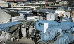 Des migrants discutent à l'extérieur de leurs tentes dans la Jungle de Calais, en France, le 30 mars 2016