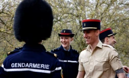 Un membre de la Garde Républicaine française échange son chapeau avec un membre de la "Number F Company Scots Guards" de l'armée britannique, à Wellington Barracks, à Londres, le 5 avril 2024