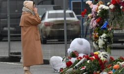 Une femme se recueille devant un mémorial improvisé prÚs du Crocus City Hall de Krasnogorsk, dans la banlieue de Moscou, théùtre d'une attaque meurtriÚre, le 23 mars 2024