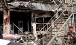 Capture d'écran d'une vidéo publiée par Hawar News Agency (ANHA) le 16 janvier 2019 montre un membre non identifié des forces de sécurité sur le lieu de l'attentat suicide contre une patrouille américaine de la coalition internationale antijihadistes dans la ville de Minbej dans le nord de la Syrie