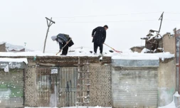 Des Afghans nettoient un toit à Kaboul, le 5 février 2017
