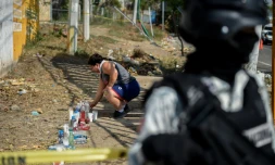 Une femme allume une bougie sur le lieu d'un accident qui a coûté la vie à 55 migrants prÚs de Tuxtla Gutierrez (Mexique), le 10 décembre 2021