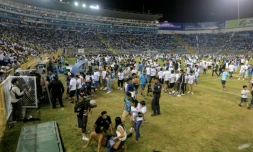Des supporters sur la pelouse du stade Cuscatlan après une bousculade pendant un match de football entre Alianza et FAS , le 20 mai 2023 à San Salvador