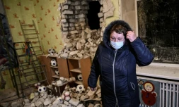 Une femme se tient parmi les décombres dans une école maternelle touchée par des obus séparatistes, à Stanitsa Louganska en Ukraine le 17 février 2022