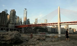 Des passants traversent le lit asséché de la rivière Jialing, un affluent du fleuve Yangtsé, dans la ville de Chongqing en Chine, le 24 août 2022
