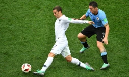 L'attaquant français Antoine Griezmann (g) marqué par le milieu uruguayen Cristian Rodriguez lors du quart de finale, à Nijni Novgorod, le 6 juillet 2018