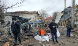 Trois hommes devant des ruines provoquées par un bombardement des forces russes à Jitomir, en Ukraine, le 2 mars 2022