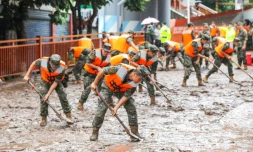 Des policiers nettoient une rue à Chongqing dans le sud-ouest de la Chine le 4 juillet 2023 après des inondations causées par des pluies torrentielles