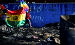 Un garçon tient le drapeau Wiphala, la banniÚre multicolore des peuples indigÚnes andins, sur un barrage routier installé par des partisans de l'ex-président bolivien Evo Morales à Sacaba, prÚs de Cochabamba, le 18 novembre 2019