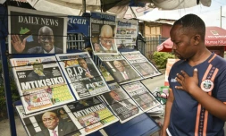 Un passant devant un kiosque à journaux de Dar es Salaam, le 18 mars 2021