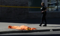 Un corps gßt sous un drap à Toronto le 23 avril 2018 aprÚs qu'une camionnette a fauché une dizaine de piétons