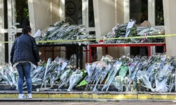 Une personne rend hommage devant le collège-lycée d'Arras, le 15 octobre 2023,  au professeur tué Dominique Bernard