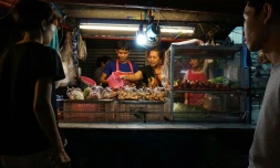 Une famille de vendeurs de rue prépare de la nourriture, le 17 avril 2017 à Bangkok