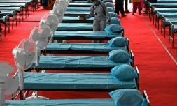 Une infirmiÚre désinfecte des lits dans un nouveau centre de traitement du Covid-19 par naturopathie, à Chennai (Inde) le 31 mai 2021