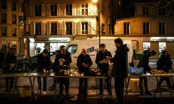 Des bénévoles des "Restos du coeur" mettent en place un point de distribution alimentaire, à Paris le 21 mars 2023
