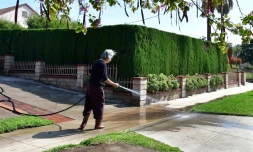 Une habitante arrose son allée à Monterey Park, en Californie, le 27 avril 2022