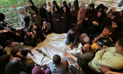 Des Palestiniens pleurent devant les corps de roches tués lors de frappes israéliennes sur des tentes de déplacés dans la zone d'al-Mawassi dans le sud de Gaza, à l'hôpital Nasser de Khan Younès, le 18 mai 2025