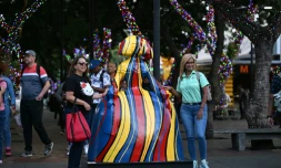 Des passantes à cÎté de l'une des sculptures réalisées par l'artiste vénézuélien Antonio Azzato dans le cadre de l'exposition de rue "Meninas Caracas Gallery", le 10 janvier 2024 à Caracas, au Venezuela