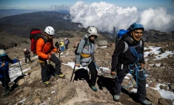 Ximena Gutierrez (c), amputée d'une jambe après un cancer des os, grimpe avec des béquilles accompagnée de ses guides vers le sommet du pic d'Orizaba (5.610 m), le plus haut du Mexique, le 24 novembre 2023