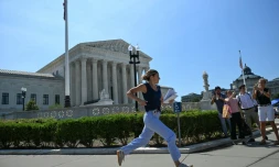 Une journaliste court devant la Cour suprême des États-Unis après qu'elle a rejeté la tentative du président Donald Trump de restreindre l'acquisition de la citoyenneté par le droit du sol, le 30 juin 2026 à Washington