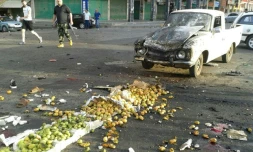Photo diffusée par l'agence officielle syrienne SANA montre un membre des forces de sécurité à côté d'une camionnette détruite par un attentat suicide du groupe Etat islamique (EI), le 25 juillet 2018 à Soueida, dans le sud du pays