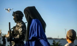 Un soldats des Forces démocratiques syriennes (FDS) escorte une femme voilée et un enfant, le 19 mai 2019 à Qamichli, en Syrie