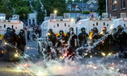 Des feux d'artifice lancés sur la police anti-émeute lors d'une troisième nuit de manifestations visant les immigrés à Ballymena, en Irlande du Nord, le 11 juin 2025