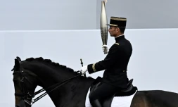 Le cavalier Thibaut Vallette, champion olympique Ă Rio en 2016, porte la flamme olympique Ă Paris, le 14 juillet 2024