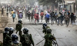 Des manifestants se mettent l'abri lors d'affrontements avec des policiers au cours d'une manifestation contre un centre de quarantaine Ebola construit par les États-Unis sur la base aérienne de Laikipia, le 9 juin 2026 à Nanyuki, au Kenya