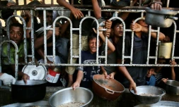 De enfants palestiniens attendent des repas préparés par une organisation de charité locale à al-Mawassi dans le sud de la bande de Gaza, le 22 juilet 2025 