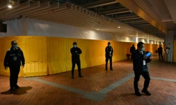 Des vigiles entourent l'emplacement de la statue "Le Pilier de la honte", autour de laquelle des barrières et des bâches ont été dressées, le 23 décembre 2021 à l'Université de Hong Kong