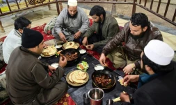 Des Pakistanais dégustent de la viande grillée au restaurant Tikka Nisar Charsi (Tikka "fumeur de haschich" en référence aux habitudes assumées du patron), à Namak Mandi, le coeur gastronomique de Peshawar, le 6 décembre 2018