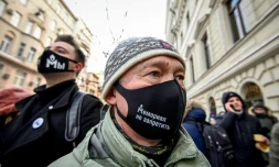 Des manifestants portant des masques frappés du logo de l'ONG Mémorial sont rassemblés devant la Cour suprême à Moscou le 28 décembre 2021