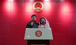 Les jeunes mariés Xue Zhenkai (g) et Liu Cuifang montrent leur livret de mariage dans un bureau de Lüliang, dans la province du Shanxi, dans le nord de la Chine, le 12 février 2025