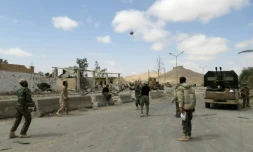 Des soldats syriens jouent au football dans les rues de la cité antique de Palmyre en Syrie, après avoir repris la ville au groupe jihadiste Etat islamique avec le soutien des forces russes, le 27 mars 2016