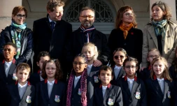 Le maire de Béziers, Robert Ménard (au centre), à cÎté d'élÚves en uniforme dans la cour de l'école primaire du Chùteau de la Chevaliere à Béziers, le 26 février 2024