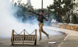 Un manifestant palestinien jette des pierres sur des forces israéliennes lors d'affrontements dans le village de Kobar, à l'ouest de Ramallah en Cisjordanie occupée, le 27 juillet 2018