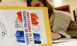 Une femme écrit dans un cahier de doléances qui sera présenté au Premier ministre à Charleville-Mezières, le 20 décembre 2018