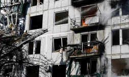 Les pompiers tentent d'éteindre un incendie dans un immeuble aprÚs un bombardement à Tchouhouïv (Ukraine) le 24 février 2022