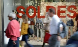 Des passants devant les vitrines des soldes Ă Paris
