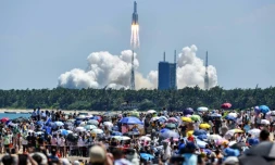 Une foule regarde le décollage de la fusée transportant le deuxième des trois modules dont la Chine a besoin pour compléter sa nouvelle station spatiale Tiangong, le 24 juillet 2022 à Wenchang (sud de la Chine)