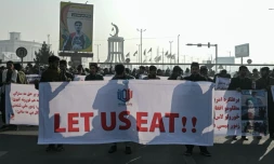 Des manifestants avec une banderole "Laissez-nous manger!" pour réclamer le déblocage des avoirs gelés de l'Afghanistan par les pays occidentaux, le 21 décembre 2021 à Kaboul