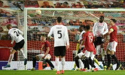 Le dĂ©fenseur danois de l'AC Milan, Simon Kjaer (g), Ă©galise de la tĂȘte en 8e de finale retour de la Ligue Europa sur le terrain de Manchester United, le 11 mars 2021